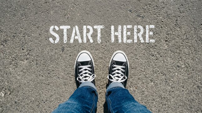 A person standing on a start here marker ready for a new beginning