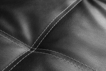 Naklejka premium Black leather upholstery with white stitching detail, luxury furniture material texture, modern interior design element