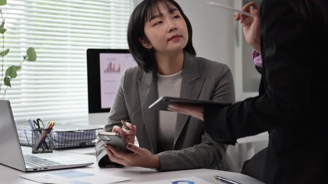 Businesswoman Listening and Taking Notes During Meeting in Modern Office
