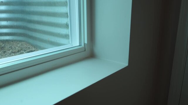 Closeup of a modern residential window frame and windowsill inside a newly built home, highlighting clean interior construction details and natural light.
