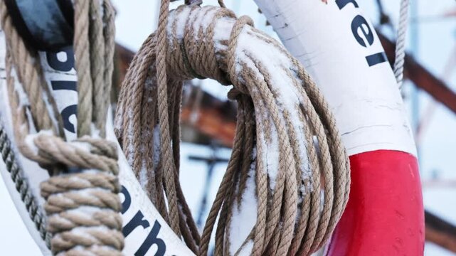 Natural fiber rope coiled up on a life buoy covered in snow