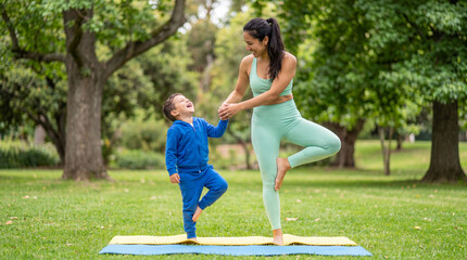 Obraz premium International Yoga Day mother son balance pose holding hands outdoor park joyful playful wellness fitness healthy lifestyle family bonding fun exercise