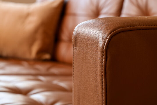 Close-up of a luxurious brown leather sofa armrest with detailed stitching and textured surface, home interior design and comfort