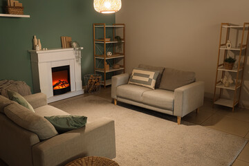 Obraz premium Cozy living room interior with modern fireplace, comfortable sofas, and stylish shelving units for home comfort