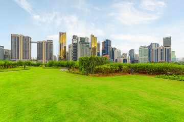 Obraz premium View of contemporary high-rise buildings across green lawn