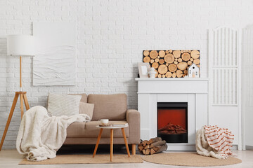 Obraz premium Cozy living room interior with modern fireplace, comfortable sofa, and minimalist decor against white brick wall