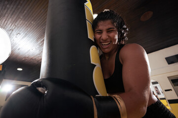 Female Boxer Training With Heavy Bag In Gym Smiling After Intense Workout