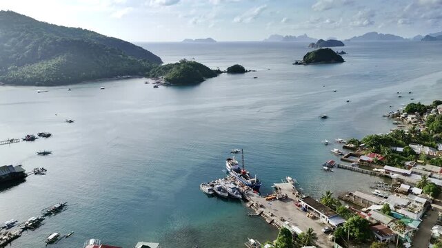 Aerial drone view of Liminangcong Port, revealing stilt houses and coastal housing along a tropical seascape, Philippines