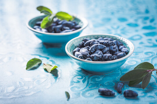 Organic honeysuckle (honeyberry) in a blue bowl on table