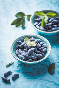 Organic honeysuckle (honeyberry) in a blue bowl on table