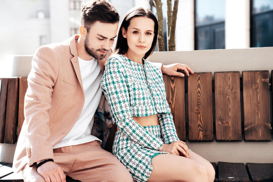 Beautiful fashion woman and her handsome elegant boyfriend in beige suit. Sexy brunette model in summer clothes. Fashionable smiling couple posing in street Europe. Brutal man and female outdoors
