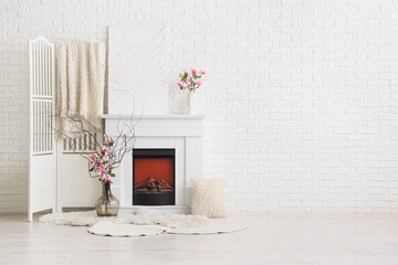 Obraz premium Modern white brick wall interior with fireplace, decorative screen, and floral arrangements for home decor