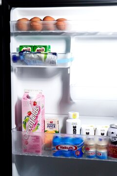 Jakarta, Indonesia - June 10th, 2026 - Egg and milk beverages products in fridge shelf isolated on vertical background.