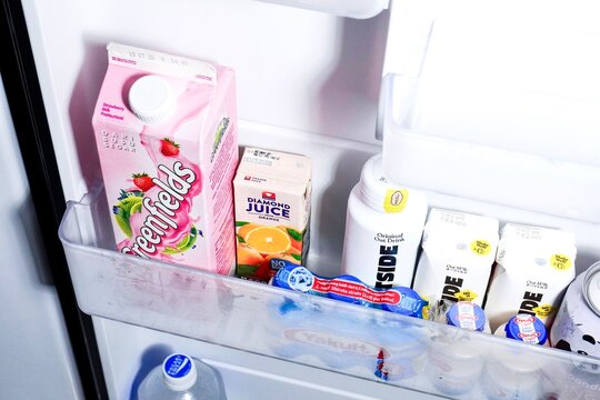 Jakarta, Indonesia - June 10th, 2026 - Greenfields, oatside, and yakult milk beverage products in fridge shelf isolated on horizontal background.