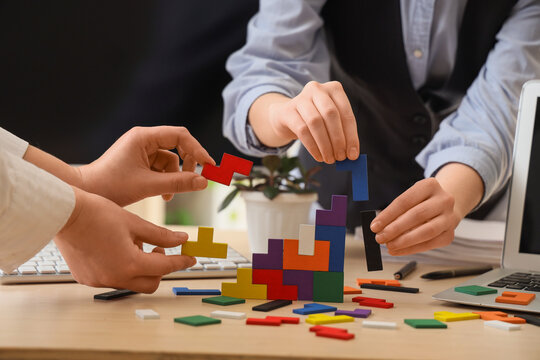 Business team collaboration building colorful tetris puzzle blocks on office desk, problem solving and strategy development