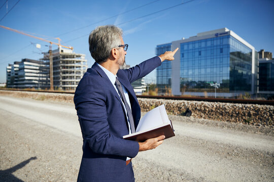 portrait of a senior businessman in front of corporate buildings