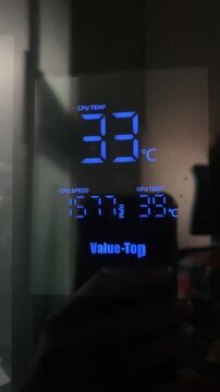 Internal view of a gaming PC with a display monitoring CPU temperature.Value top with Temperature Display. Computer cooling system next to the temperature thermometer.  Case Mod concept with Cpu.