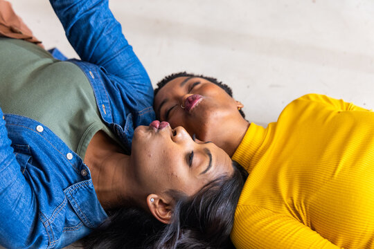 Blue denim jacket and green ribbed top with yellow ribbed sleeve are lying on pale floor