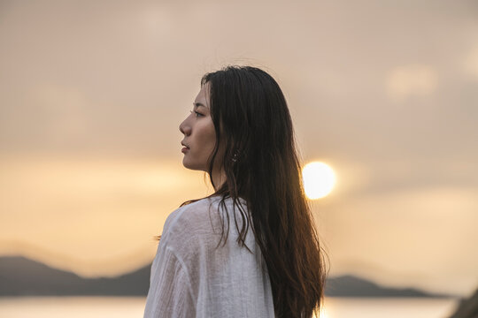 夕暮れの海にいる女性