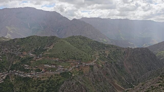 Panoramic view of a deep mountain canyon with green forested slopes and dramatic sunrays breaking through clouds in spring.
📍 Hawraman Takht, Kurdistan, Iran 