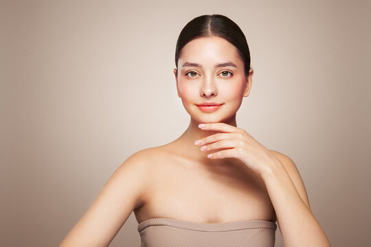 Beauty woman applying cream on her face. Young woman with clean fresh skin. Model with a jar of face cream