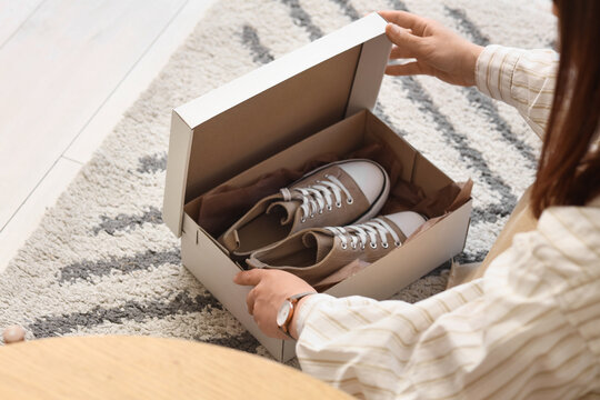 Unboxing new beige canvas sneakers in cardboard box, online shopping delivery and footwear fashion