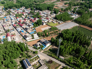 Obraz premium Aerial view of rural residential area with farmland and forest landscape