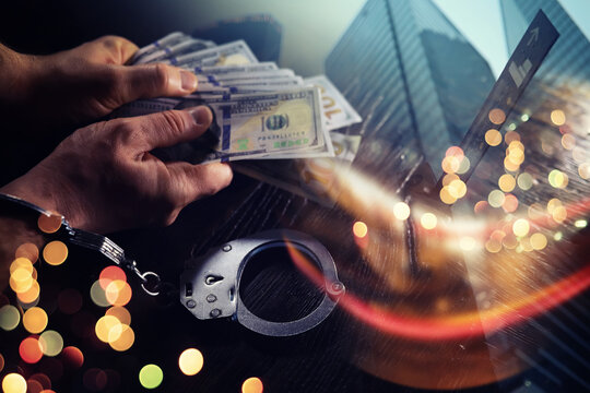  Double exposure city and hands of a man with handcuffs on a background of us dollars. Fraud, cyber crime concept. Arrest of an entrepreneur in the workplace.