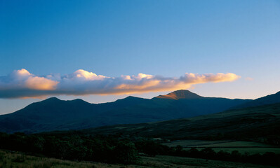 Fototapeta premium a natural landscape showcasing a sky that graduates from deep blue at the top to a lighter hue, then a horizontal formation of clouds