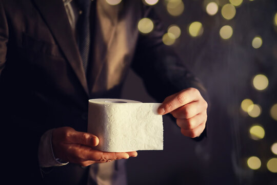 Businessman Holding a pile of Toilet Paper, copy space. Toilet papers is the new currency concept.