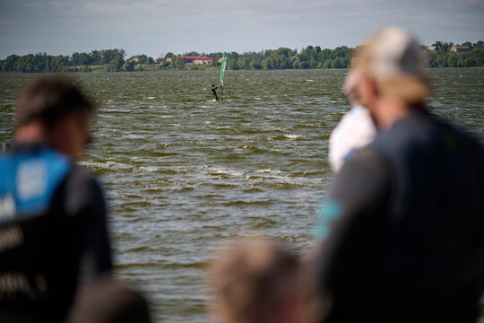 A windsurfer gliding across the water of a lake, Znin, Kujawsko-Pomorskie, Poland, Europe.