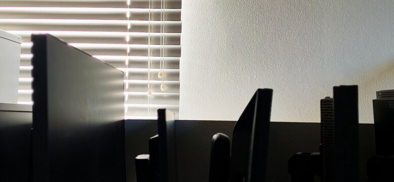 Abstract tech workspace background, high contrast silhouette of PC monitors and office interior.