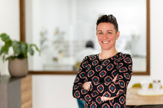 Friendly professional woman smiling with arms crossed