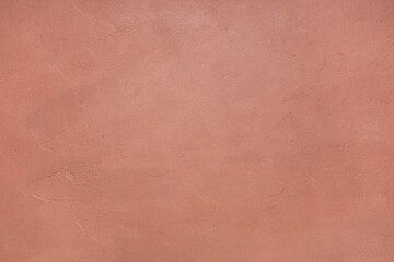 Fototapeta premium Textured peach wall background with rough plaster surface, abstract design element for interior decor and graphic projects