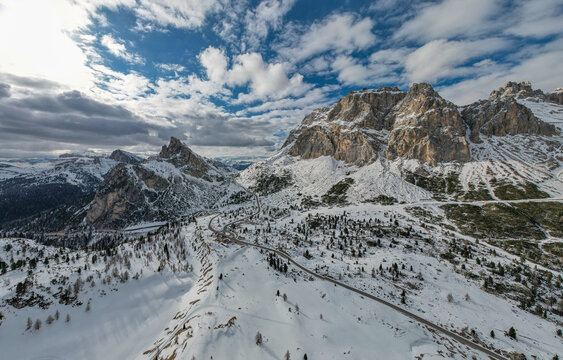Panoramic View of Falzarego Pass with Snowy Peaks and Winding Road, Dolomites, Italy