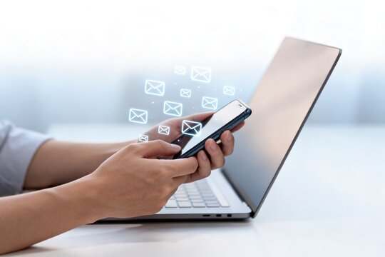 Person using smartphone with email icons
