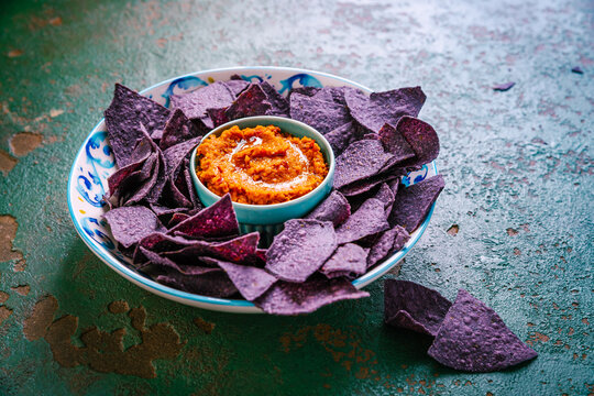 Violet tortilla chips with red salsa