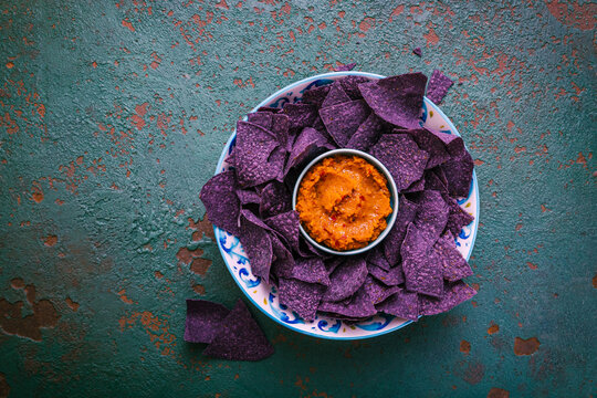 Violet tortilla chips with red salsa