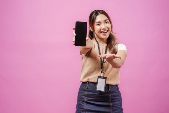 Cheerful young Asian woman in brown shirt presenting copy space on the smartphone she holds.