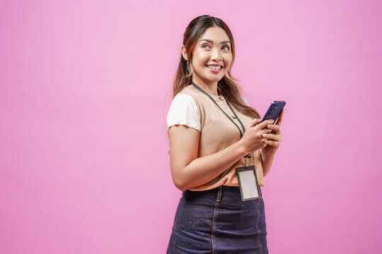 Pretty young Asian woman is smiling while holding cell phone to text someone or open social media.