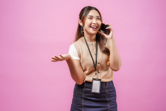 Young Asian woman wearing brown shirt smiling and having a call with someone.