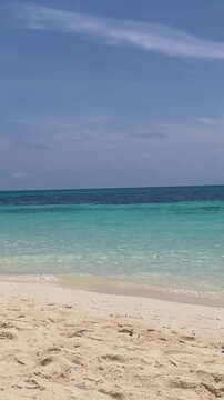 
Calm turquoise ocean ripples on a white sand beach under a clear blue sky in Boracay, Philippines.
