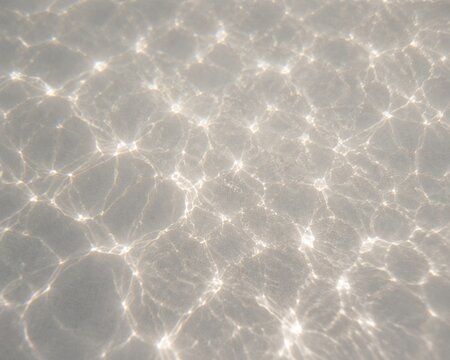 Abstract water caustic light patterns creating bright reflective textures, perfect for summer, pool and luxury backgrounds.