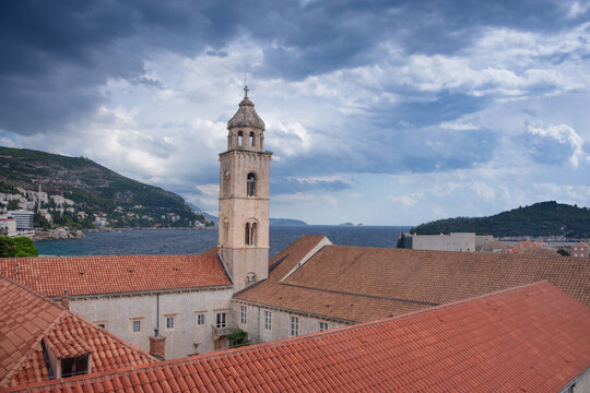 Dubrovnik Old Town with red terracotta roofs, the historic bell tower of the Dominican monastery and the harbor on the blue Adriatic Sea, in Croatia