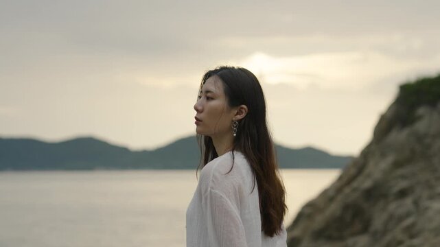 夕暮れの海にいる女性