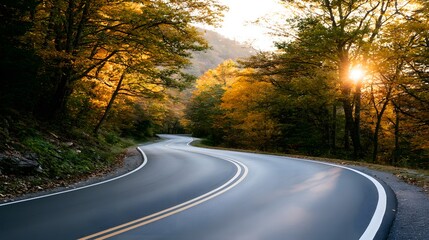 Fototapeta premium Winding asphalt road through autumn forest at sunrise, scenic highway curve, business journey concept and road trip background