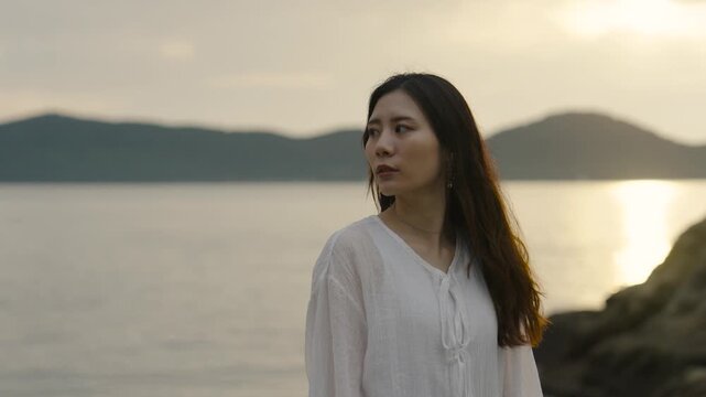 夕暮れの海にいる女性