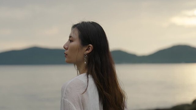 夕暮れの海にいる女性