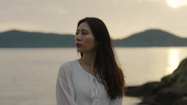 夕暮れの海にいる女性