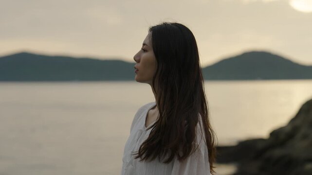 夕暮れの海にいる女性